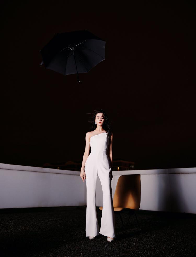 热巴穿斜肩连体裤撑黑伞 眼神霸气酷飒十足