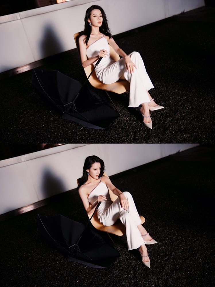 热巴穿斜肩连体裤撑黑伞 眼神霸气酷飒十足