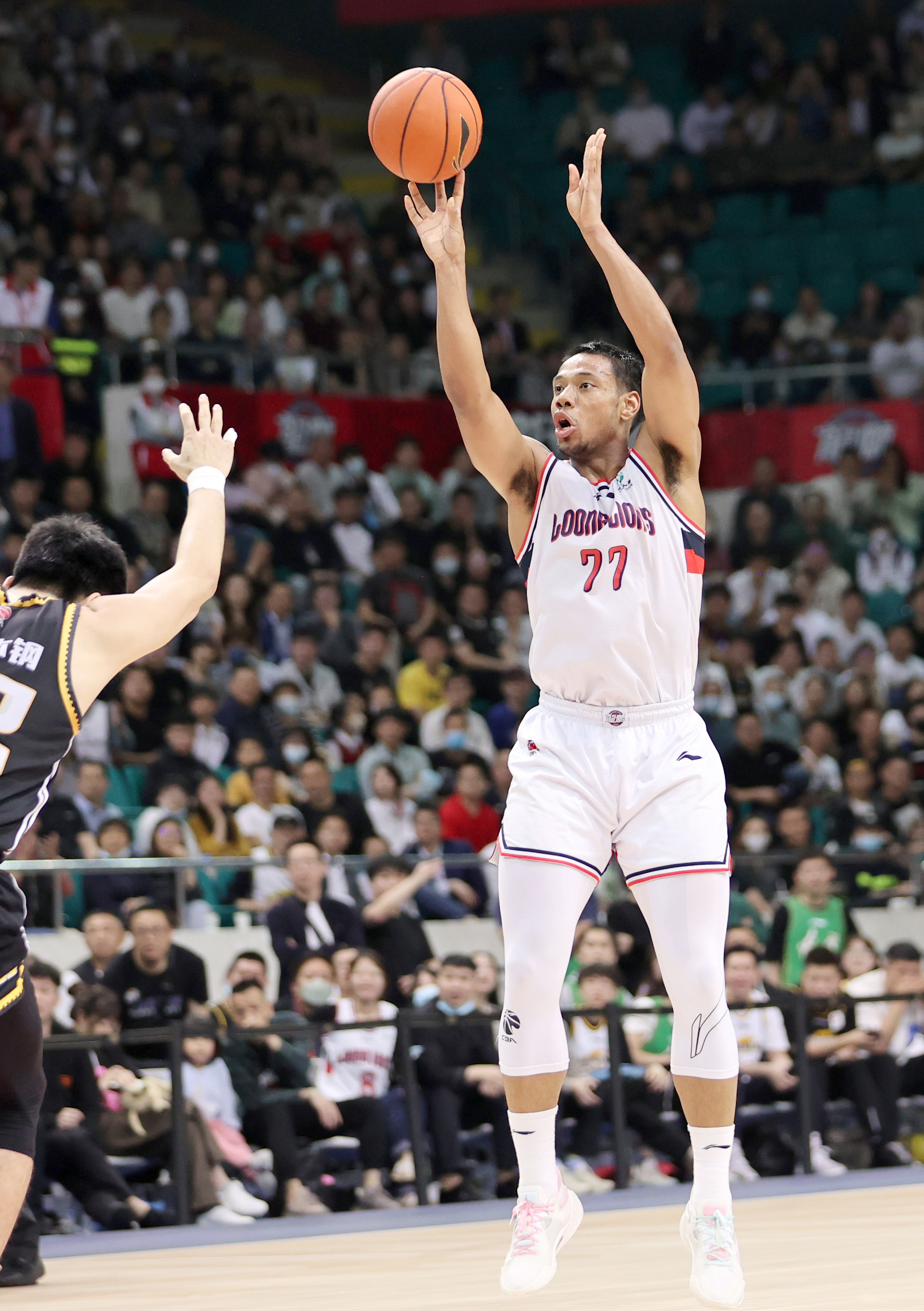 4月3日,广州龙狮队球员祝铭震(右)在比赛中投篮.