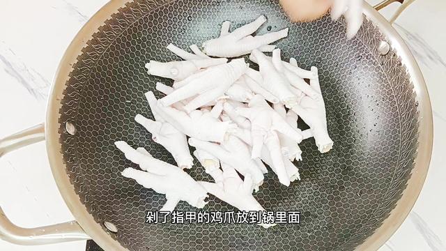 煮開半鍋水,水沸騰後,把雞腳倒入鍋中,加入少許料酒,去腥味,把雞腳