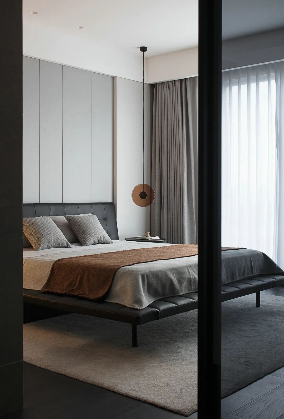 卧室床头墙以护墙板装饰,摆上一张黑色的床铺,搭配灰白配的床单,让